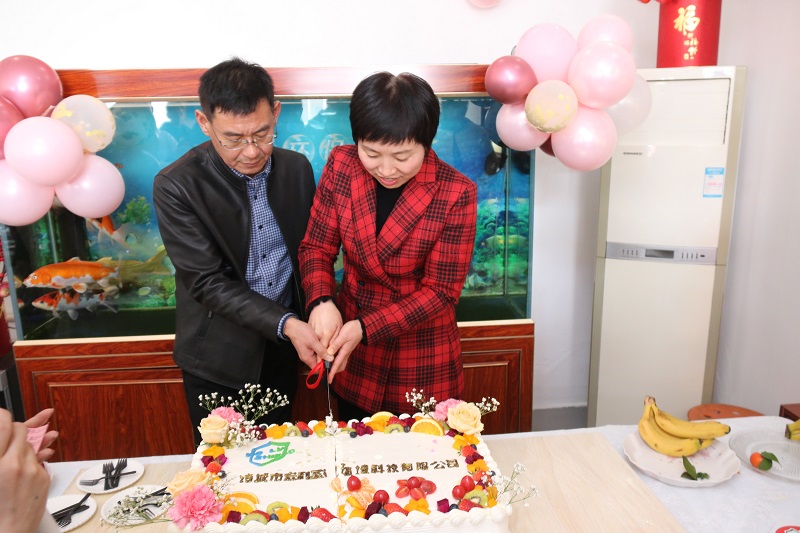 The general manager of holy shield cuts the cake for the staff